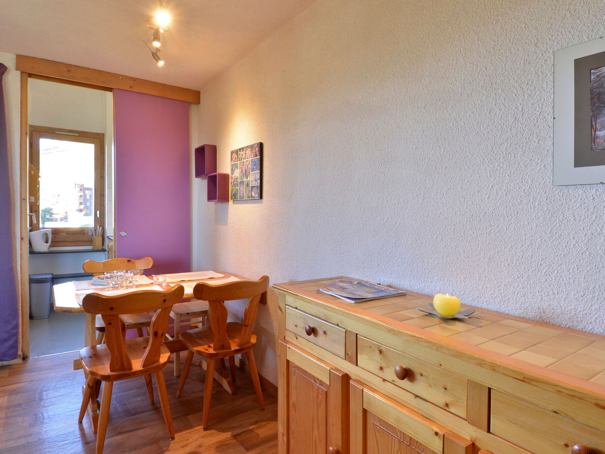 Una cucina accogliente con mobili in legno, un tavolo da pranzo e una finestra con vista sulla città.
