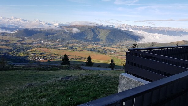A panoramic view of a mountainous landscape with a town in the valley below.