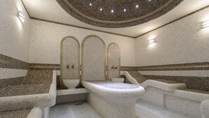 Een moderne spa-ruimte met een vrijstaand bad, zithoeken en decoratieve wandtegels.