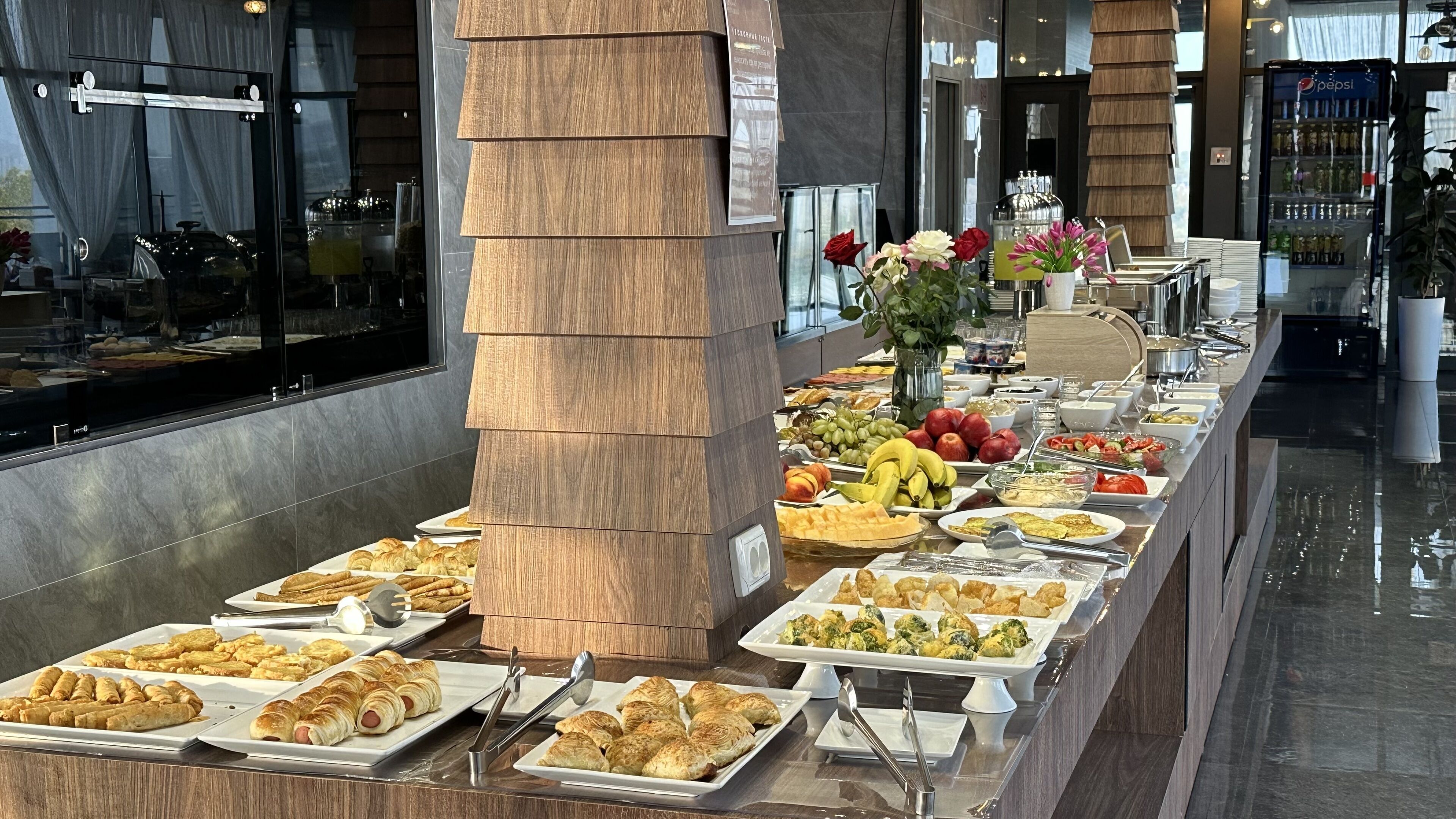A buffet with various food items and a decorative pillar.