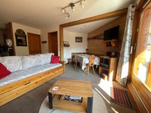 Un salon confortable avec un canapé, une table basse et une table à manger.