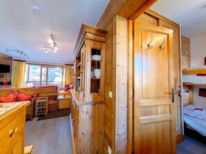 A wooden interior with a dining area, a kitchen, and a bunk bed. - Bright Spacious Apartment · Near Slopes · Balcony · Free Wi-Fi (Saint-Martin-de-Belleville)