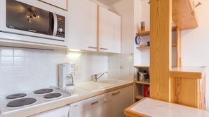 A modern kitchen with white cabinetry, a built-in microwave, a coffee maker, and a dishwasher. - Renovated 2-room apartment, 6 people, southwest balcony, La Rosière (La Rosière)