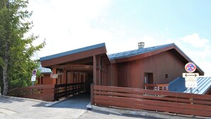 Un bâtiment en bois avec une enseigne indiquant « Le Belvédère » et un panneau interdisant le stationnement.