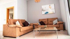 Ein modernes Wohnzimmer mit zwei Sofas, einem Couchtisch und einer Hängeleuchte.