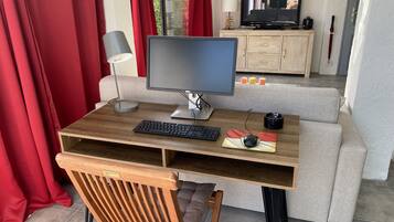Een werkplek thuis met een bureau, computer, toetsenbord en muis.