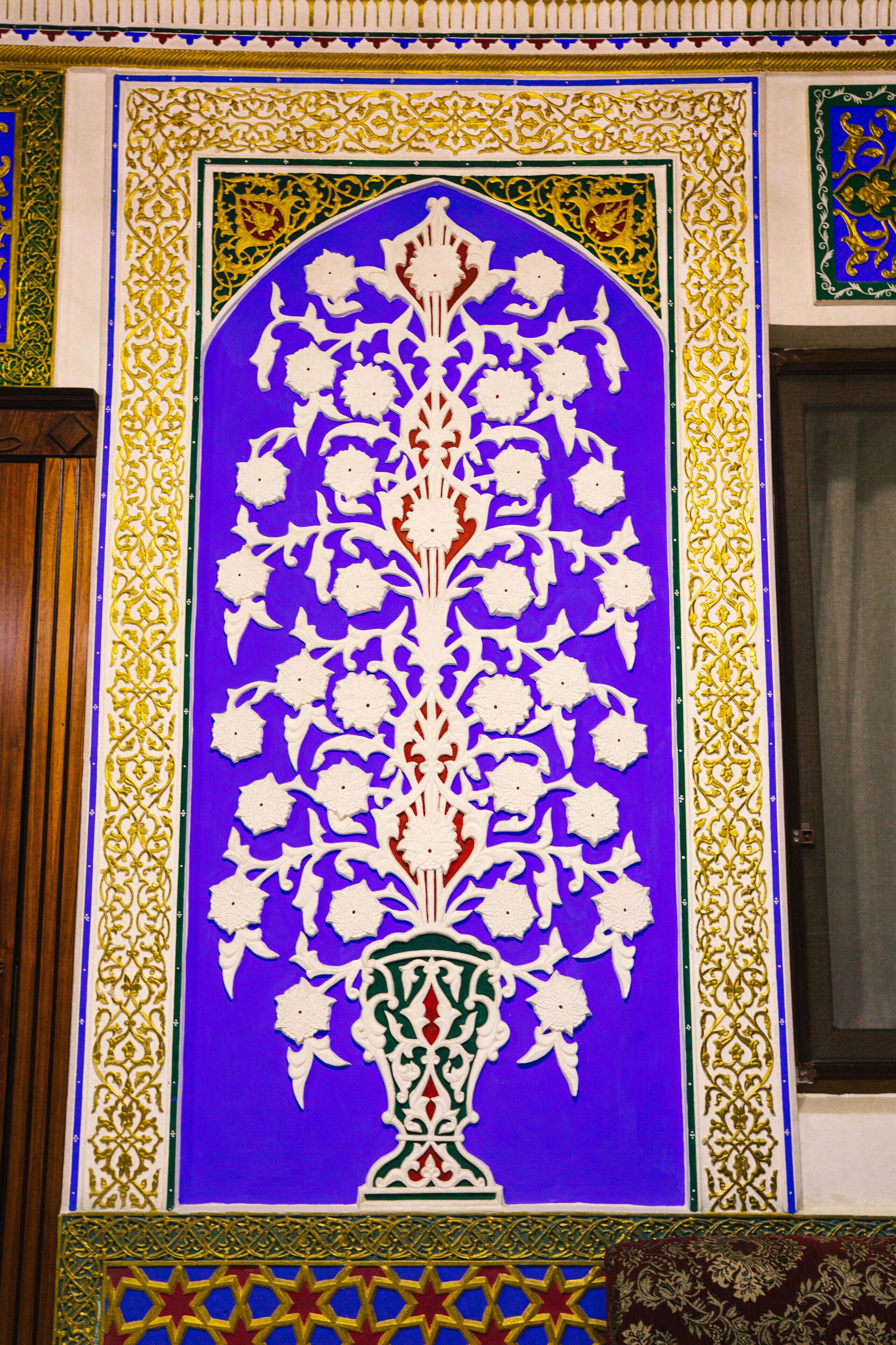 A detailed floral pattern on a wall with intricate borders.