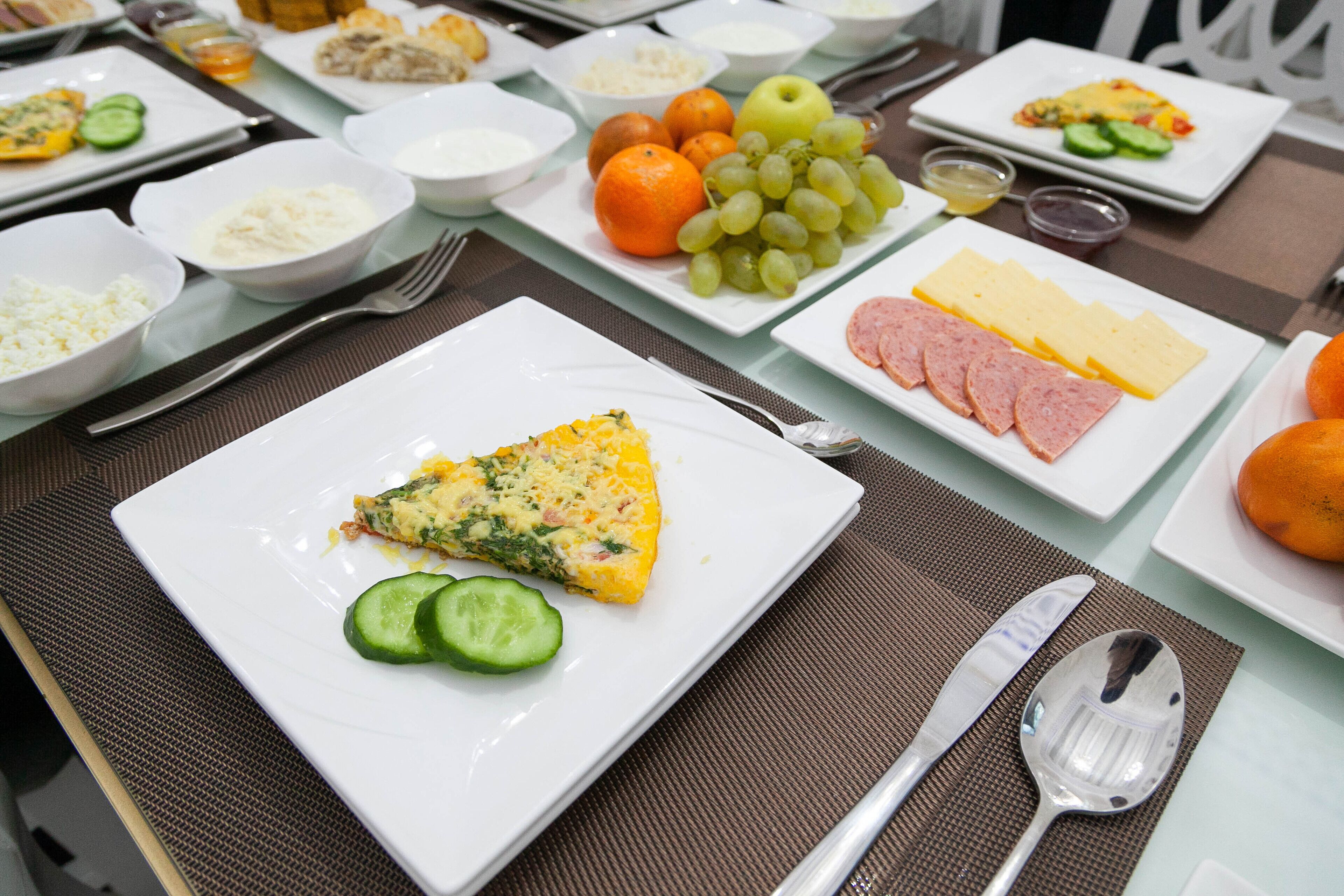 A breakfast buffet with various food items and utensils.
