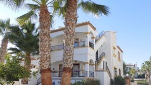 A multi-story building with balconies, palm trees, and a clear sky. - Costa Blanca Los Dolses, Spanish cozy apartment, solarium garden pool beach golf (Los Dolses)