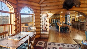 A log cabin interior with a chessboard, wooden shelves, and a moose head. - Gorgeous, remote lodge on 100+ acres, 15 min from downtown Indiana (Indiana)