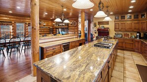 A spacious kitchen with granite countertops, wooden cabinets, and pendant lighting. - Gorgeous, remote lodge on 100+ acres, 15 min from downtown Indiana (Indiana)