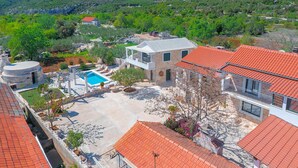 A residential property with a swimming pool, stone buildings, and a red-tiled roof. - Pet friendly home in Bogomolje (Bogomolje)