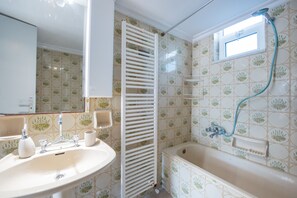 A bathroom with a sink, mirror, towel rack, and bathtub. - Fully Equipped House Nearby the Beach (Rhodes)