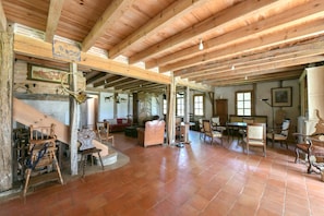 Une pièce spacieuse avec un haut plafond en bois, des meubles en bois rustiques et une cheminée.