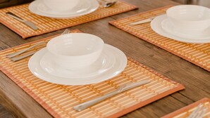 A dining table set with placemats, plates, bowls, and cutlery. - Hot Tub Mountain View Dog Friendly Modern Chalet (Linden)