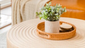 A round wooden table with a woven tray and a potted plant. - Hot Tub Mountain View Dog Friendly Modern Chalet (Linden)