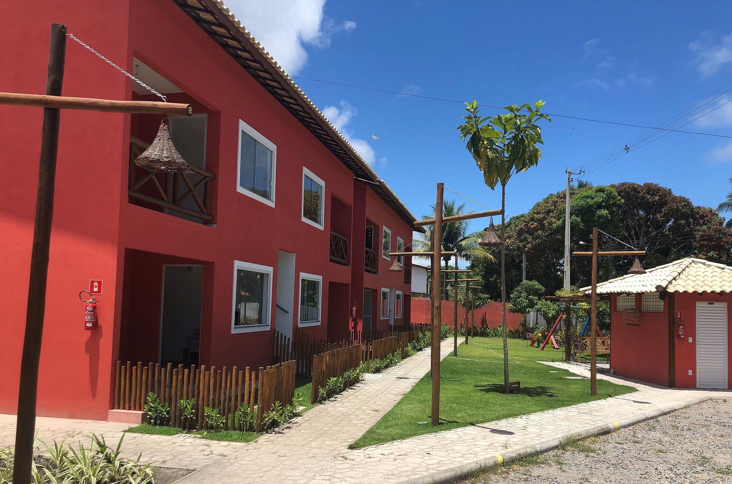 A red building with multiple windows and a small attached structure.