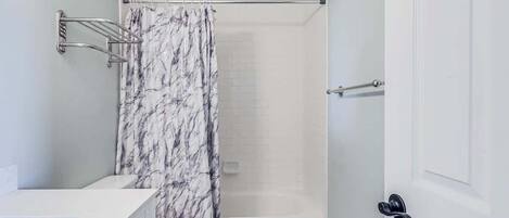 Een badkamer met toilet, douche en een witte deur.