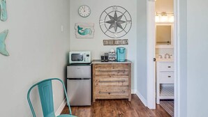 Une cuisine équipée d’un four à micro-ondes, d’une machine à café et d’un meuble en bois.