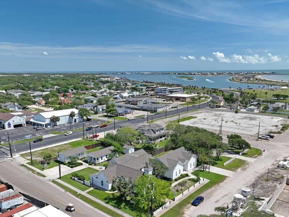 Un quartier résidentiel avec des maisons, un parking et une étendue d’eau en arrière-plan.