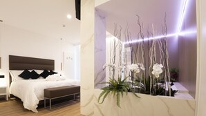 Un dormitorio moderno con una cama grande, mesitas de noche y una pared de acento de mármol decorada con plantas.