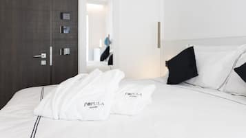 A hotel room with a neatly made bed, a large mirror, and a door with a handle.