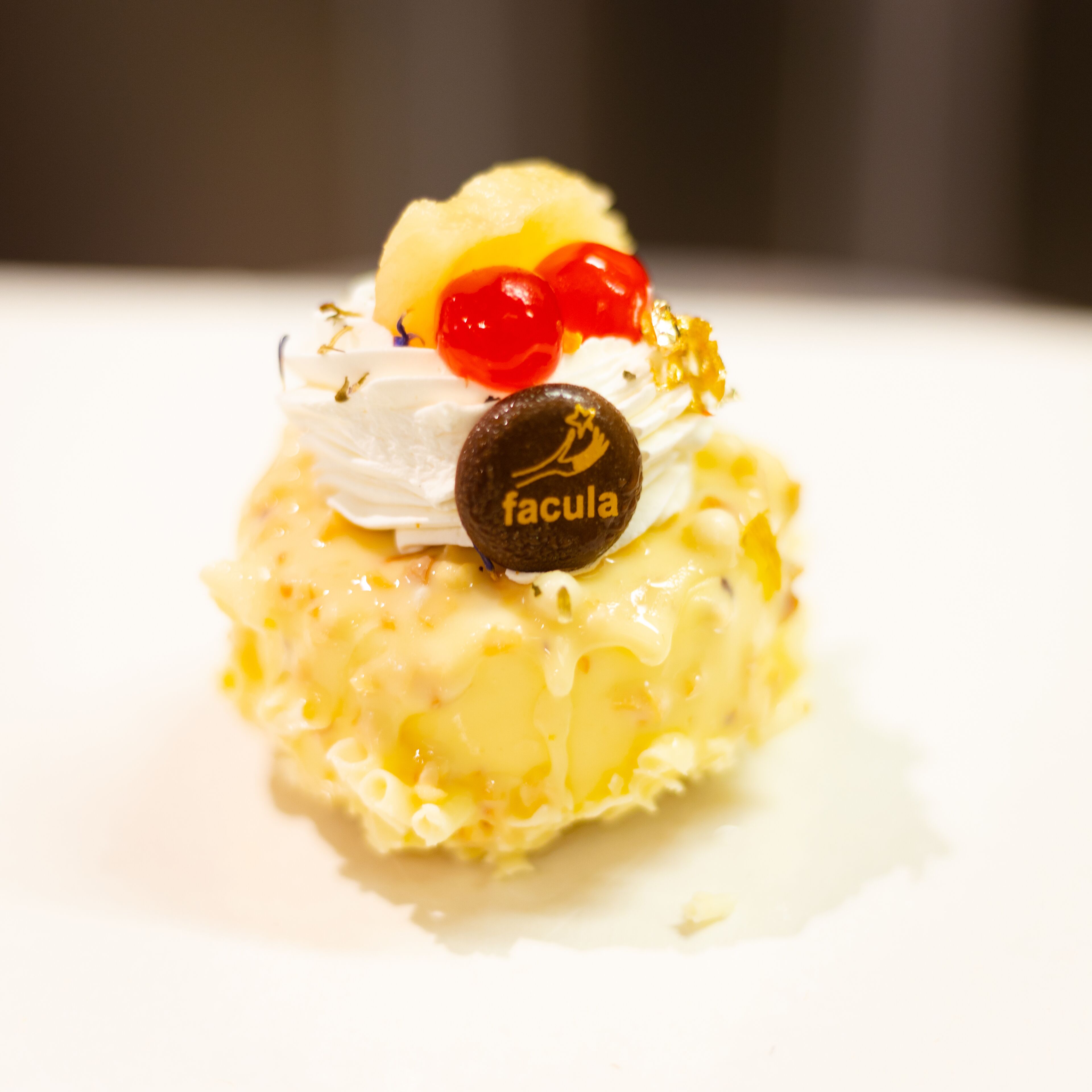 Un dessert surmonté d’un morceau de chocolat portant l’inscription « facula ».