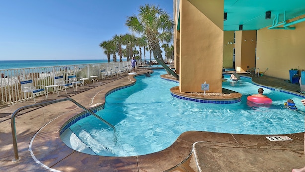 A pool area with a clear view of the ocean, palm trees, and a lifeguard stand. - 2 King bedrooms in this 15th floor condo at the Splash w/Beach Chairs! (Panama City Beach)