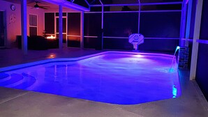 An indoor swimming pool with a basketball hoop, surrounded by a covered area with a fire feature. - Lovely Villa with a pool/ Ideal for long stays / Message for discounts. (Davenport)