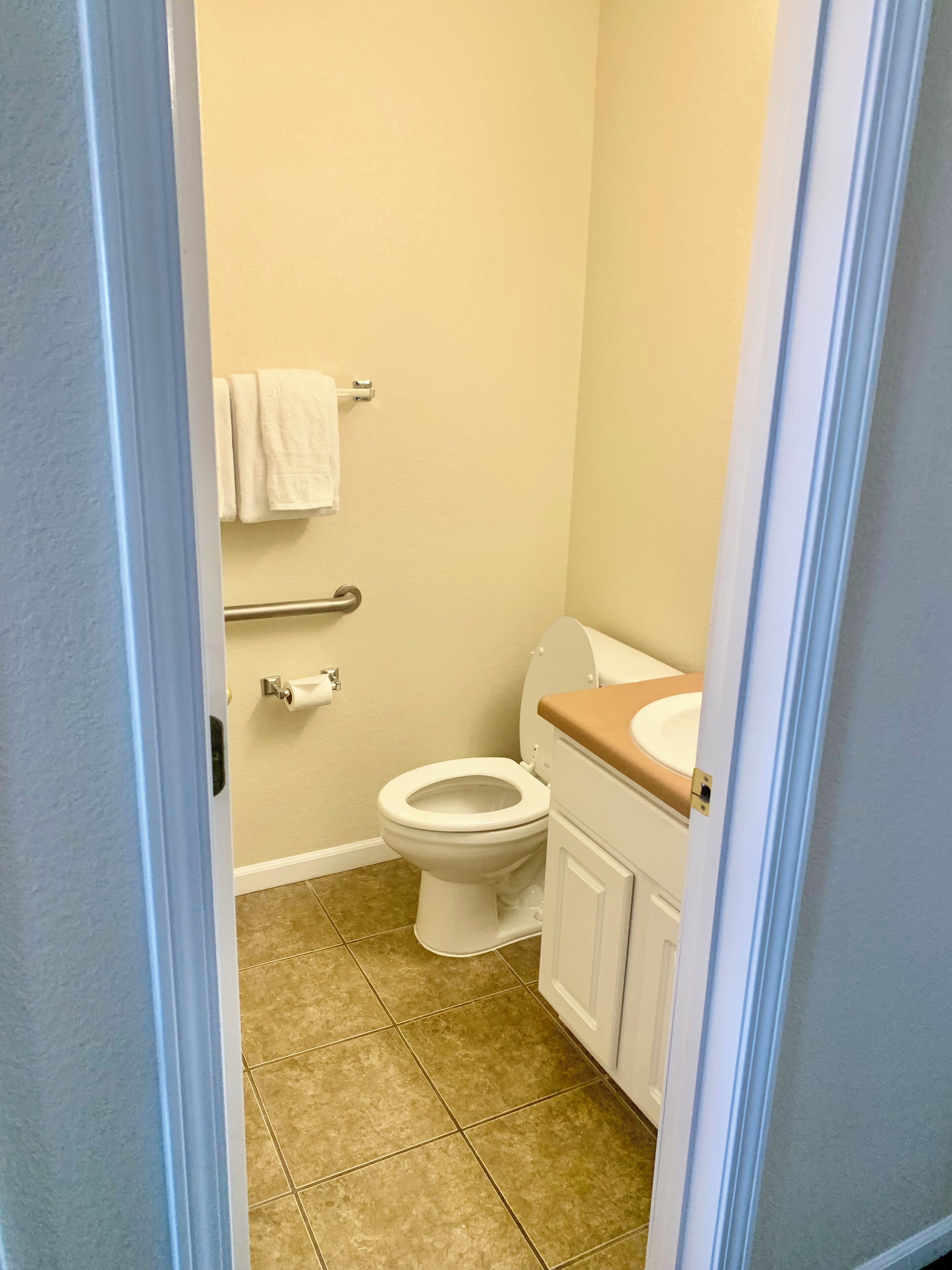 Une salle de bain équipée de toilettes, d’un lavabo et d’un porte-serviettes.
