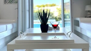 A modern living room with a white table, a potted plant, and a martini glass.