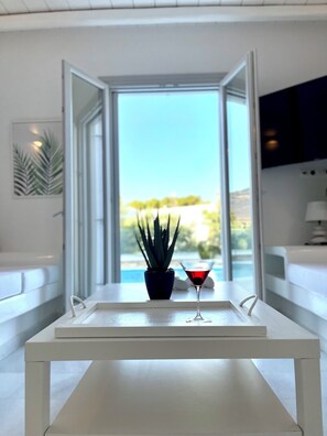 A modern living room with a white table, a potted plant, and a martini glass.