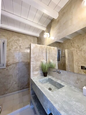 Een bad/douchecombinatie, een haardroger, handdoeken, zeep