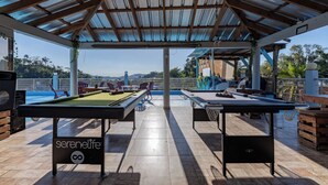 An outdoor pool area with two pool tables, a speaker, and a view of the surrounding landscape. - Stylish loft in the city/ Wi-fi / Jacuzzi (Samaná)