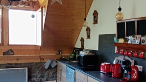 Une cuisine moderne avec des meubles en bois, un lave-vaisselle encastré et un bar pour prendre le petit-déjeuner.