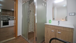A modern bathroom with a glass shower enclosure, wooden vanity, and a large mirror. - House in Gerês for 2 people with fireplace (Gerês)