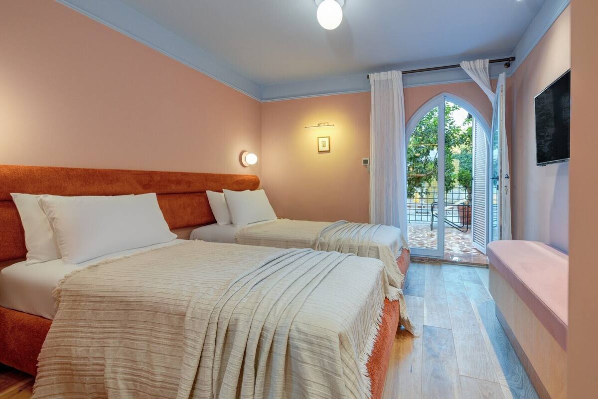 Une chambre d’hôtel avec deux lits, un petit balcon et une vue sur l’extérieur.