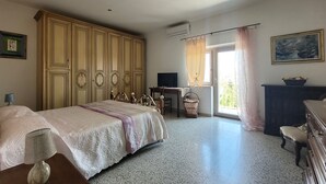 A bedroom with a bed, a desk, a television, and a window with curtains. -  Large ecohome a Tricarico near Matera, with kitchen,parking, green (Tricarico)