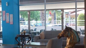A seating area with a sofa, a table, and a decorative horse statue. - Astoria Life Hotel (Marmaris)