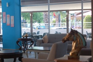 Uma área de estar com um sofá, uma mesa e uma estátua decorativa de um cavalo.