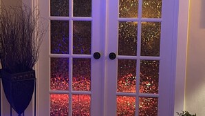 Puertas dobles con paneles de vidrio satinado y un ojo de cerradura en el centro.