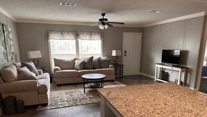 A living room with a sofa, coffee table, and TV stand.