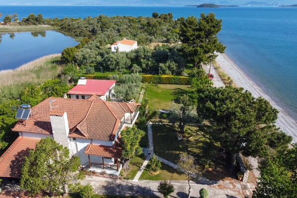 A coastal property with a house, a garden, and a beach.