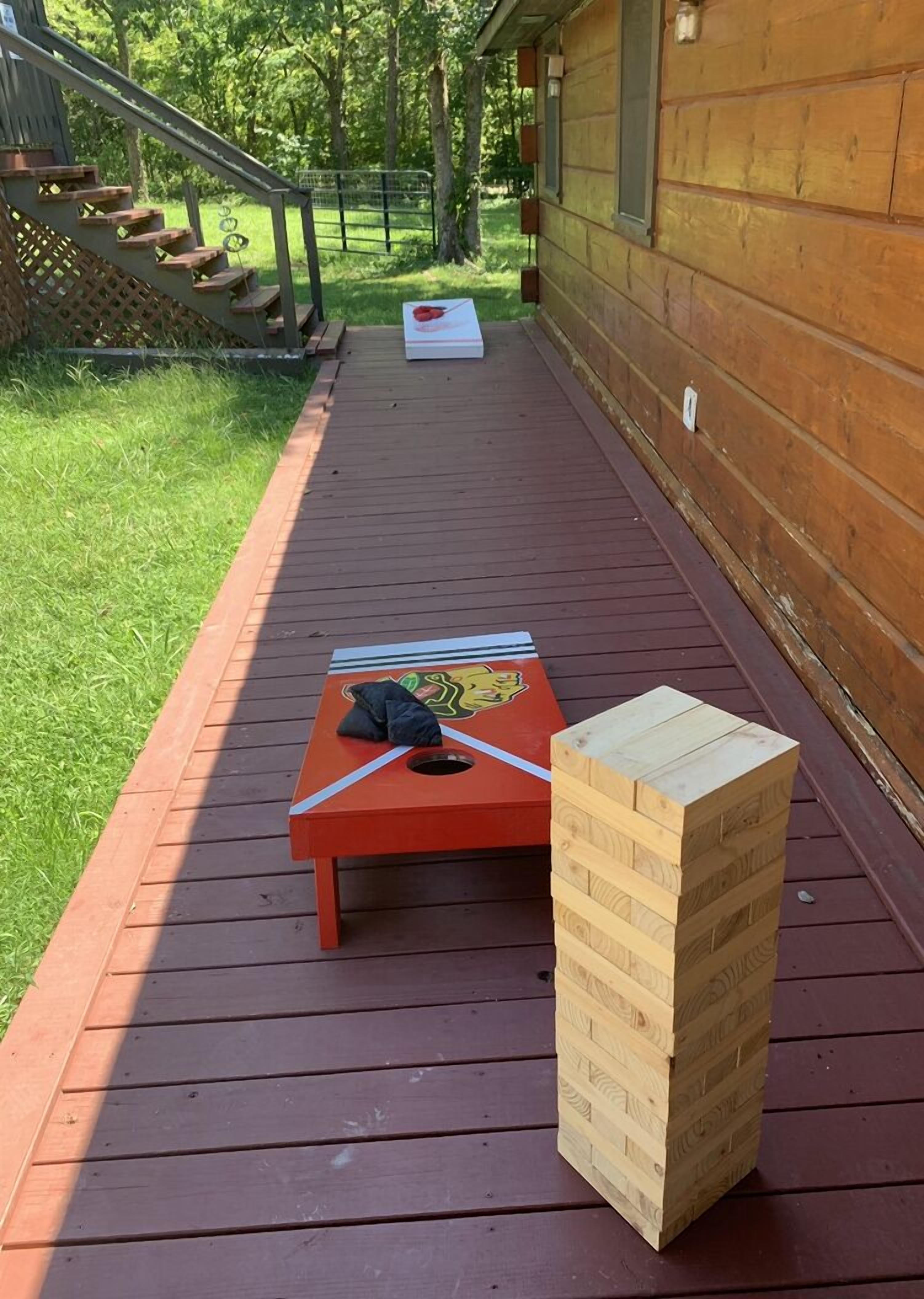 A wooden deck with a red table and a stack of wooden blocks.
