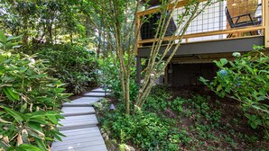 A wooden deck leading to a building with a large window and a balcony. - Lake Escape - Hot Tub & Lake Access - Pet Friendly (Hendersonville)