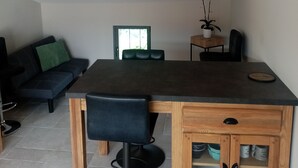 Un coin repas avec une table en bois, des chaises noires et un buffet contenant de la vaisselle.