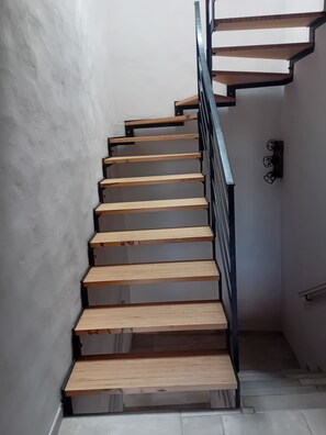 Una escala amb graons de fusta i barana metàl·lica.