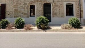 Un bâtiment en pierre avec un toit recouvert de tuiles, de nombreuses fenêtres et une porte.