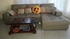 A living room with a sofa, a coffee table, and a TV. - Villa of 100 m2 flower gardens and fruit trees (Le Moule)