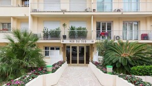 A multi-story hotel entrance with a stone-paved walkway, potted plants, and a sign reading "MER DU SUD". - Waterfront - splendid apartment (Cannes)